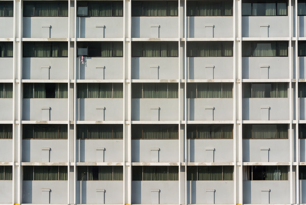 Fassade eines großen Gebäudekomplexes mit sich wiederholenden Fensterachsen